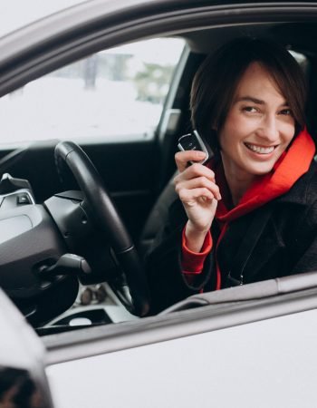 Woman sitting inside electro car while charging it